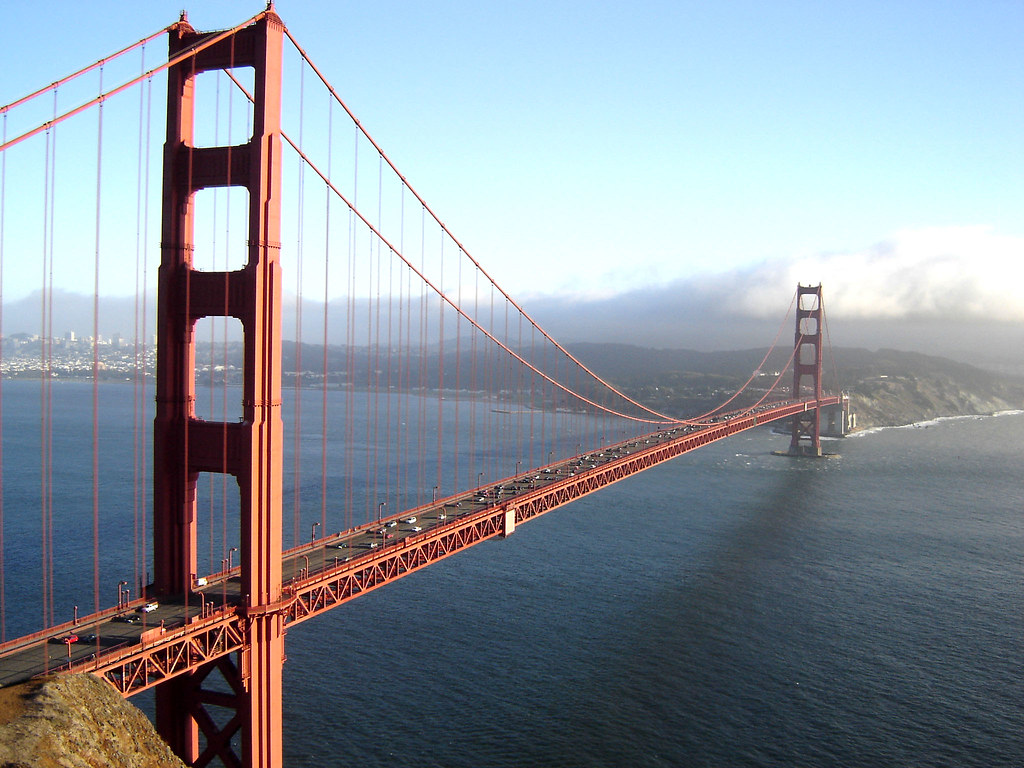 A bridge at dusk carrying continuous streams of traffic — the pipe never goes dark.
