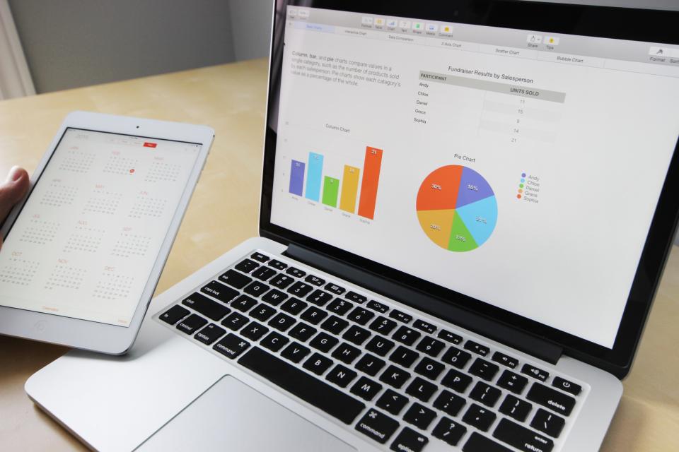 Two colleagues reviewing revenue charts together at a bright desk